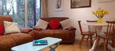 a living room with a couch and a table at Woodland Retreat in Uny Lelant
