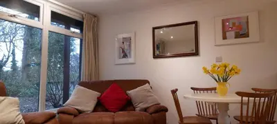 a living room with a couch and a table at Woodland Retreat in Uny Lelant