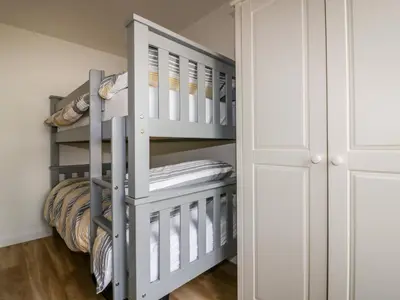 a bunk bed in a small room with a ladder at Avalon in St. Agnes