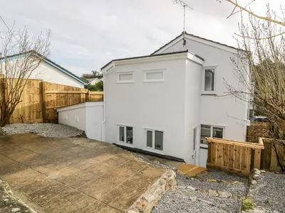 a white house with a wooden fence at Avalon in St. Agnes