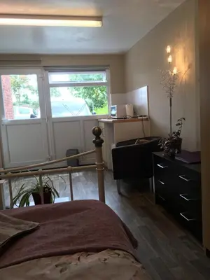 a bedroom with a bed and a desk and window at Cosy annex. in Threemilestone