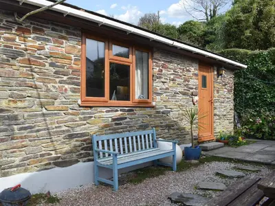 a blue bench sitting outside of a stone house at Sea View - Uk30589 in Talland