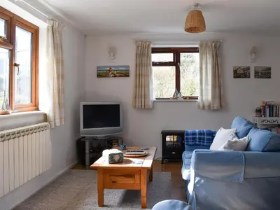a living room with a blue couch and a tv at Sea View - Uk30589 in Talland