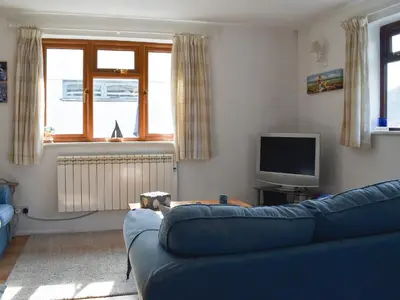 a living room with a blue couch and a tv at Sea View - Uk30589 in Talland