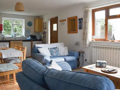 a living room with a blue couch and a kitchen at Sea View - Uk30589 in Talland