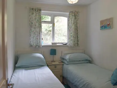 two beds in a room with a window at Sea View - Uk30589 in Talland