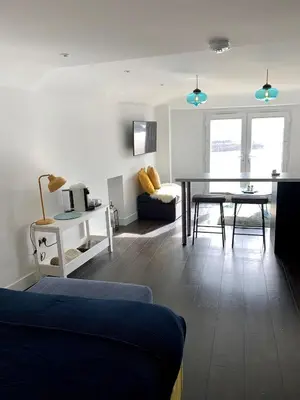 a living room with a couch and a table at Modern studio apartment with stunning views! in St Ives