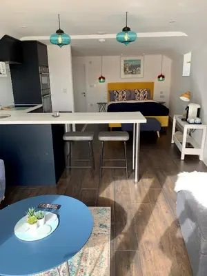 a kitchen and living room with a table and a couch at Modern studio apartment with stunning views! in St Ives