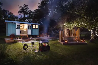 a tiny house in a yard at night at The Wriggly Tin & Baa Spa at Tregoose Old Mill in Newquay