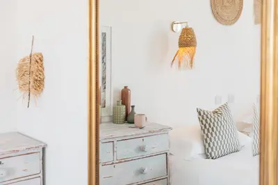 a mirror in a bedroom with a dresser at Harbour View House in St Ives