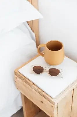 a pair of glasses on a table next to a bed at Harbour View House in St Ives