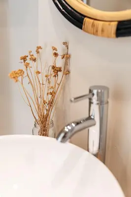 a bathroom sink with a vase with flowers in it at Harbour View House in St Ives