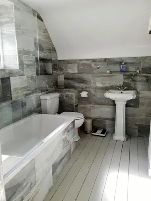 a bathroom with a tub and a toilet and a sink at Truly Paradise Cottage in Golant