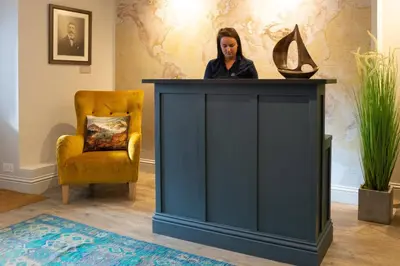 a woman standing at a podium next to a chair at Marazion Hotel in Marazion