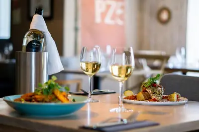 a table with two glasses of wine and a plate of food at Marazion Hotel in Marazion