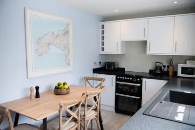 a kitchen with a table with a bowl of fruit on it at Marazion Hotel in Marazion