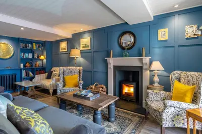 a living room with blue walls and a fireplace at Marazion Hotel in Marazion