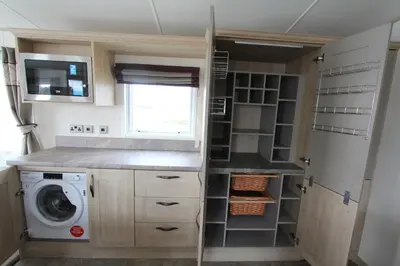 a small kitchen with a washer and dryer at Valley View with a luxurious hot tub in Newquay