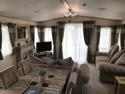 a living room with a couch and a table at Valley View with a luxurious hot tub in Newquay