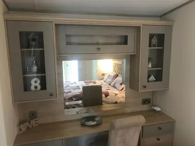 a bedroom with a bed in a large mirror at Valley View with a luxurious hot tub in Newquay