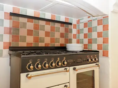 a stove top oven in a kitchen with tiles at Trevena Lodge in Tintagel