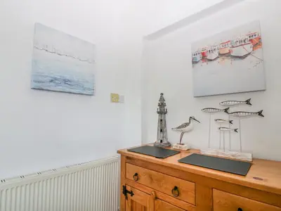 a room with a wooden dresser with sculptures on it at Trevena Lodge in Tintagel