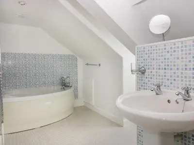 a bathroom with a sink and a bath tub at Trevena Lodge in Tintagel