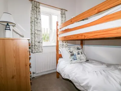 a bedroom with a bunk bed and a window at Gull Cottage in Tintagel