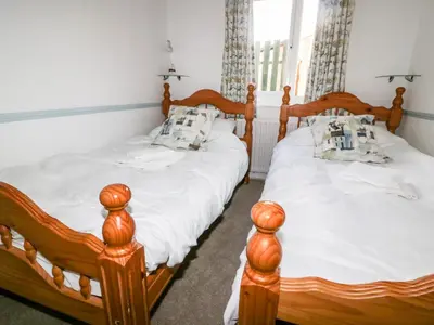 two twin beds in a room with at Gull Cottage in Tintagel