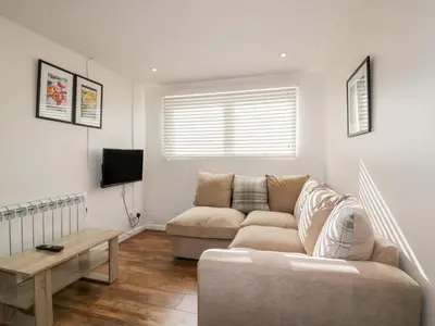 a living room with a couch and a table at Cove Cottage in Tintagel