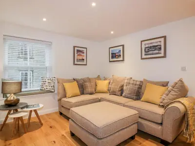 a living room with a couch and a table at Captain's Cabin in St Austell