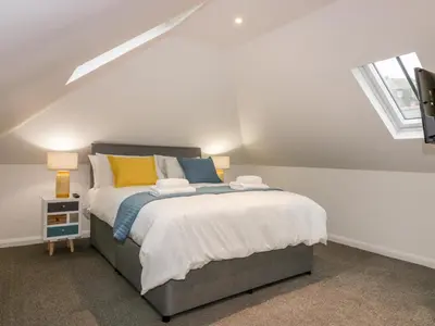 a bedroom with a large bed in a attic at Captain's Cabin in St Austell