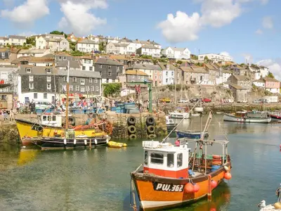 a group of boats are docked in a harbor at Captain's Cabin in St Austell