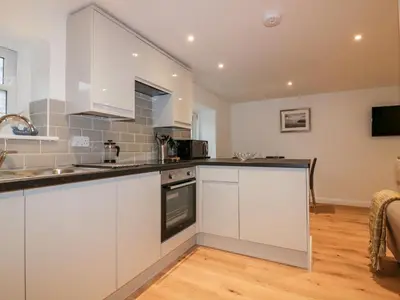 a kitchen with white cabinets and a counter top at Captain's Cabin in St Austell