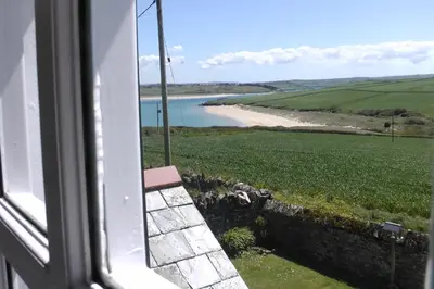 a view of a beach from a window at Lellizzick Farmhouse in Padstow