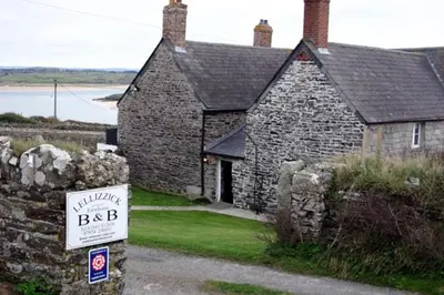 an old stone building with a sign in front of it at Lellizzick Farmhouse in Padstow