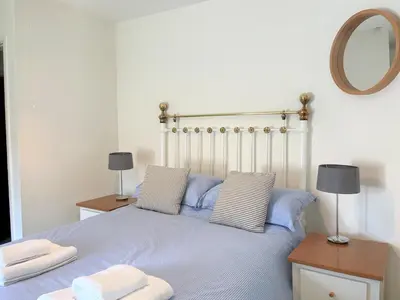 a bedroom with a bed with two pillows and a mirror at Little Pengelly Farm in Crowan
