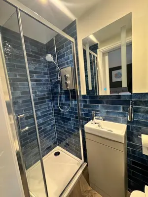 a bathroom with a shower and a toilet and a sink at The London Inn in Padstow