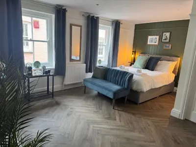 a bedroom with a bed and a blue chair at The London Inn in Padstow