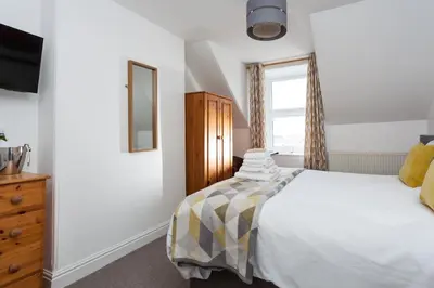 a bedroom with a large bed and a window at The Olive Branch in St Ives