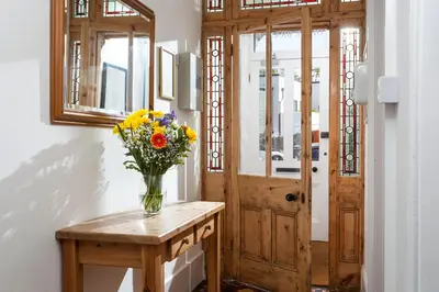 a vase of flowers on a table next to a door at The Olive Branch in St Ives