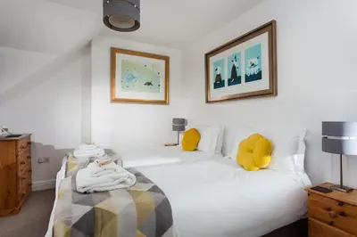 a bedroom with a white bed with towels on it at The Olive Branch in St Ives