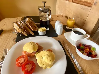 a table with a plate of food with eggs and tomatoes at The Olive Branch in St Ives