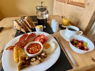 a breakfast tray with a plate of breakfast foods and coffee at The Olive Branch in St Ives