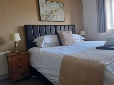 a bedroom with a bed with white sheets and pillows at Thurlestone House in St Ives