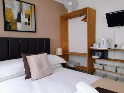 a hotel room with two beds and a tv at Thurlestone House in St Ives