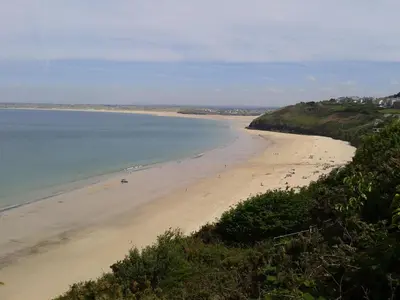 a beach with a group of people in the water at Thurlestone House in St Ives