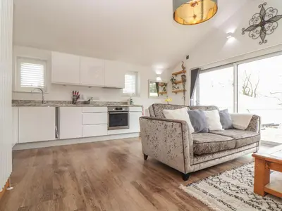 a living room with a couch and a kitchen at Chycoose in Truro