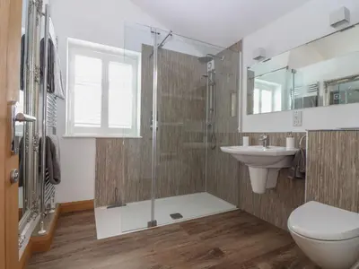 a bathroom with a shower and a toilet and a sink at Chycoose in Truro