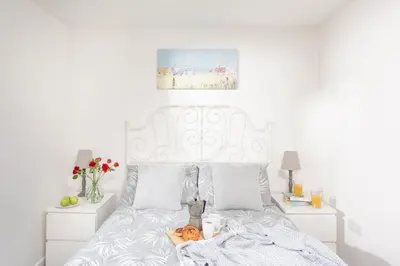 a bedroom with a white bed with a pumpkin on it at Wheal Jewel- Beautifully Fitted Wooden Lodge Helston Cornwall in Helston